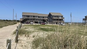 A beachfront building with multiple balconies and a parking area. - Sw 3 Finns Up 1 Bedroom Condo by RedAwning (Hatteras)