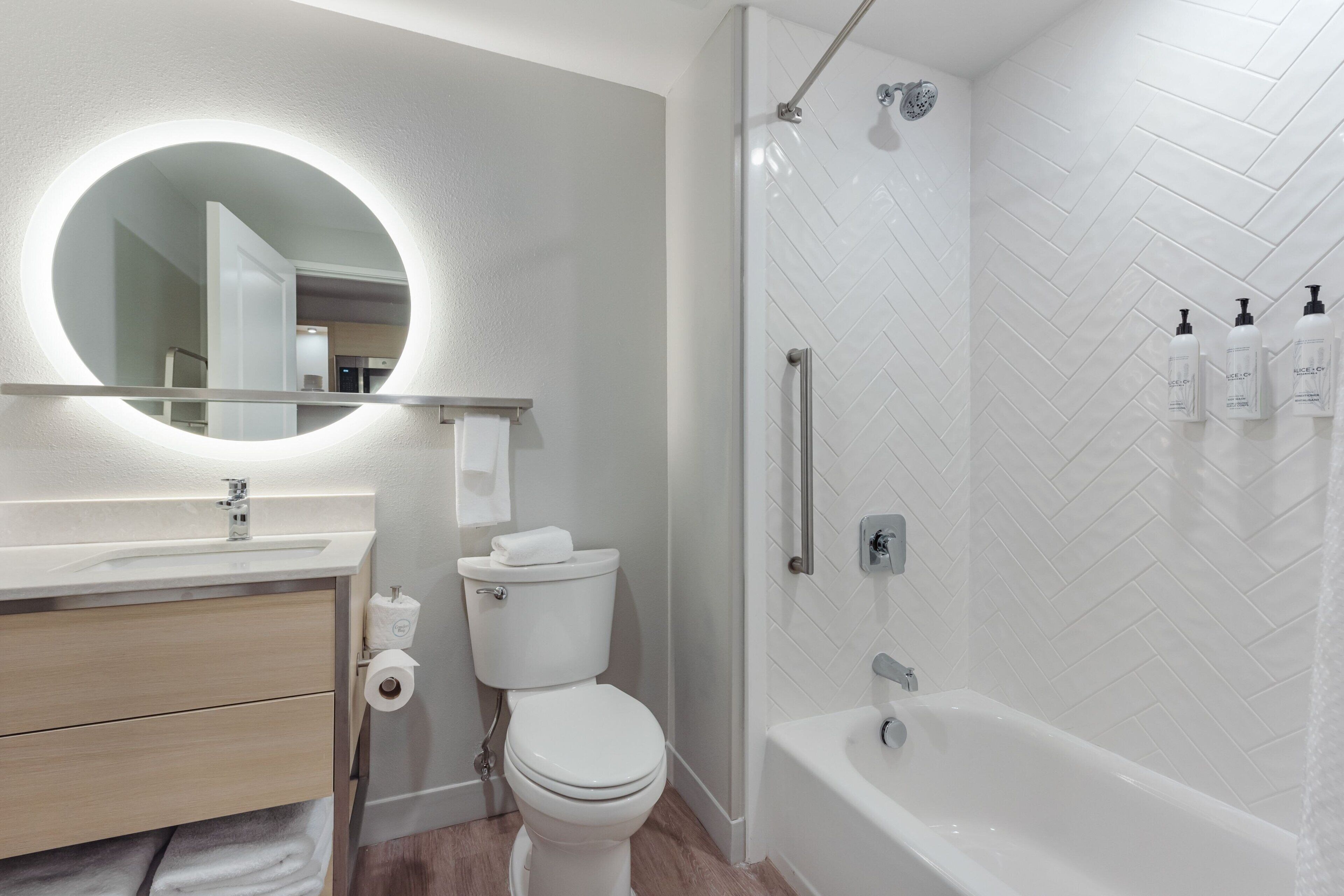A modern bathroom with a toilet, sink, and shower.