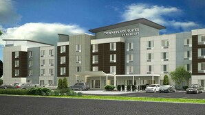 Ein modernes Hotel mit Namensschild, mehreren Etagen und einem Parkplatz.