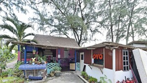 Un pequeño edificio rústico con techo de lámina corrugada y un letrero que dice "OYO".