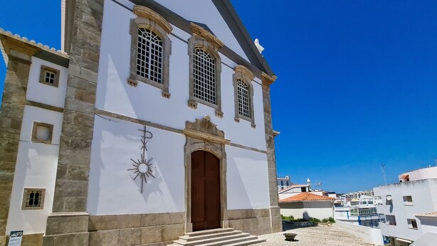 Un edifici històric amb una entrada destacada, un rellotge i una decoració en forma d'estrella.