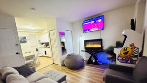A living room with a flat-screen TV, a fireplace, and a bean bag chair. - Entire Unit-5min to M&TBank Camden Yards (Baltimore)
