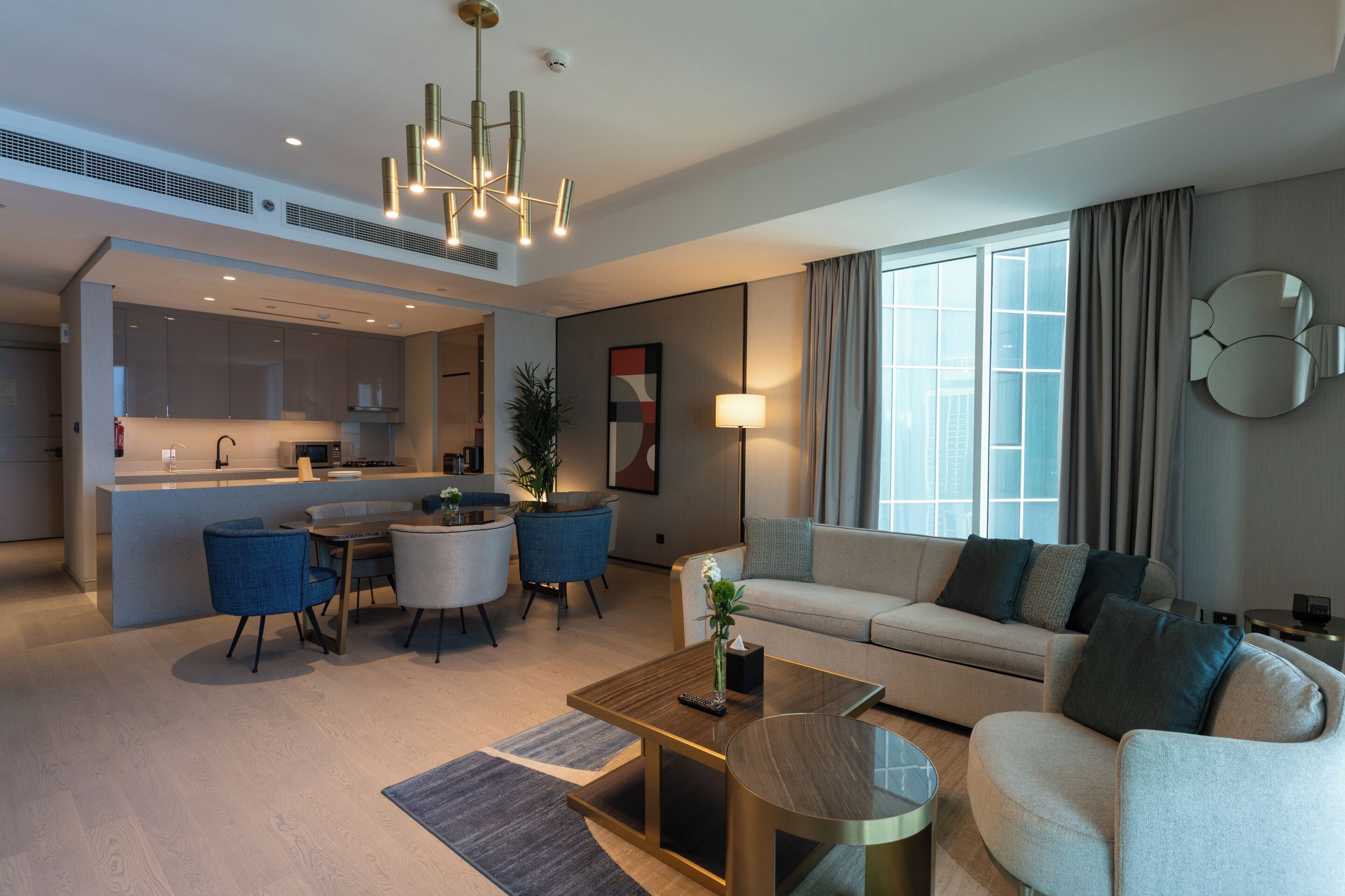A modern living room with a sofa, coffee table, and dining area.