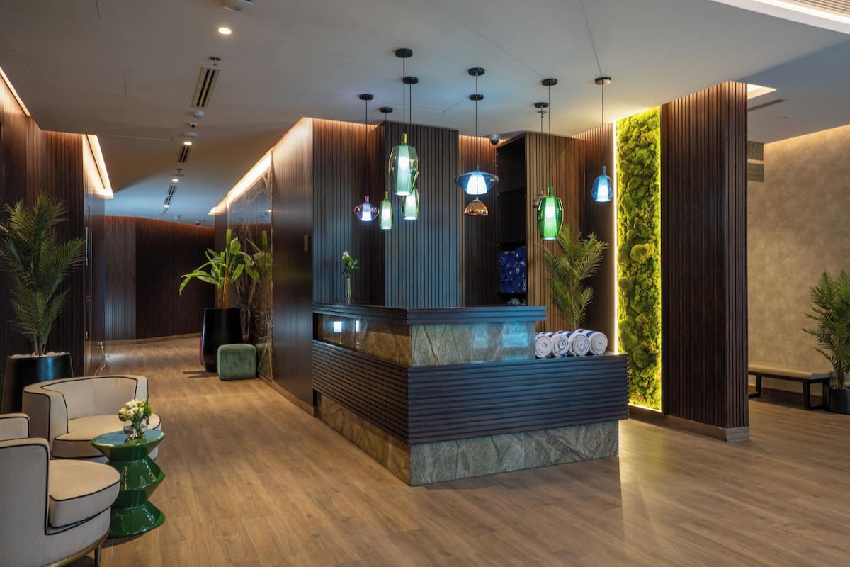 A reception area with a reception desk, seating, and a vertical garden wall.