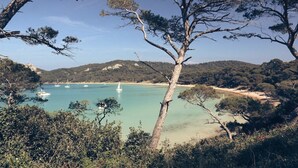 A coastal landscape with clear turquoise waters, boats, and a sandy beach. - Prestigious villa in the heart of a vineyard near BORMES-LES-MIMOSAS (La Londe-les-Maures)