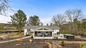 Une maison moderne dotée d’une grande porte vitrée, d’un patio avec des meubles d’extérieur et d’un chemin en pierre.