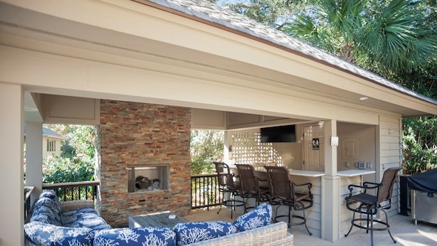 A covered outdoor patio with a brick fireplace, wicker furniture, and a bar area. - 3 Sprunt Pond at The Sea Pines Resort (Hilton Head Island)