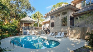 A swimming pool with lounge chairs, a covered patio, and a house with a balcony. - 3 Sprunt Pond at The Sea Pines Resort (Hilton Head Island)