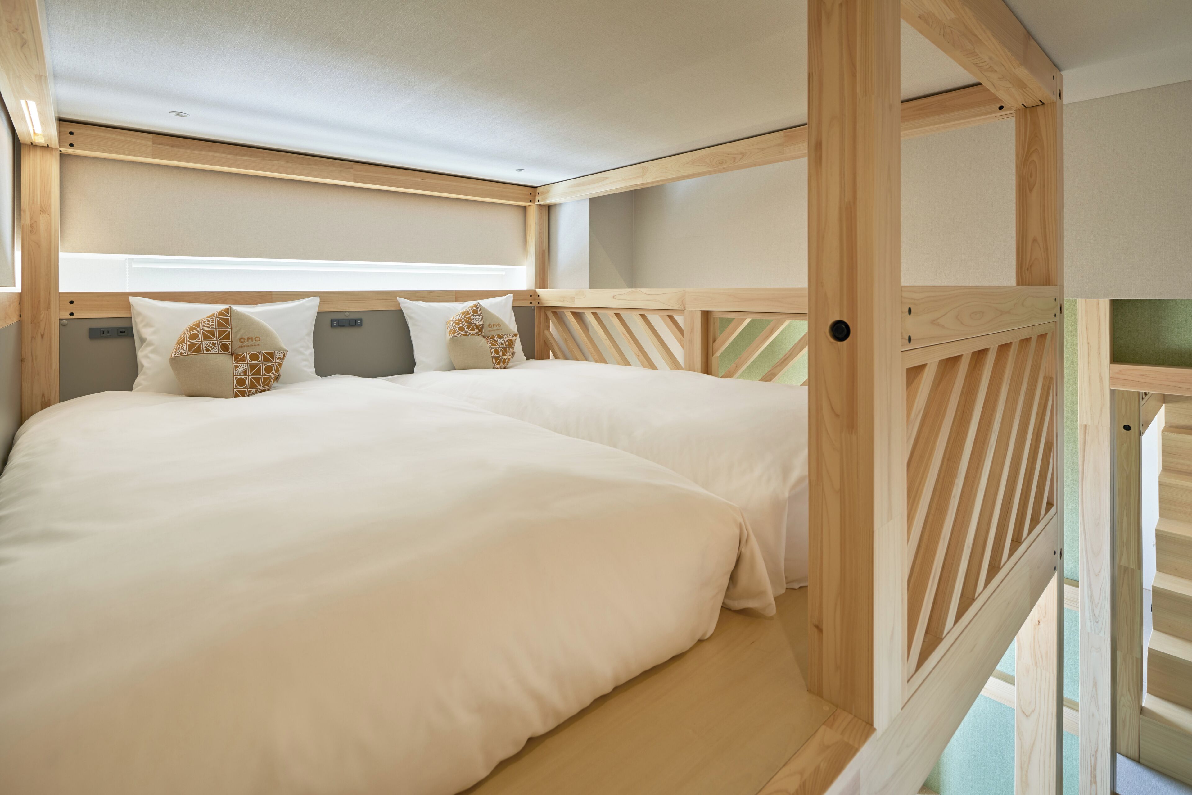 Un dormitorio con dos camas, cabecero de madera y una ventana.