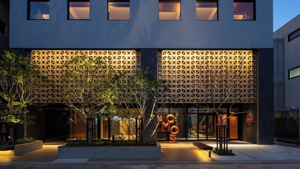 A modern building with a geometric facade, a landscaped entrance, and illuminated signage. - OMO5 Okinawa Naha by Hoshino Resorts (Naha)