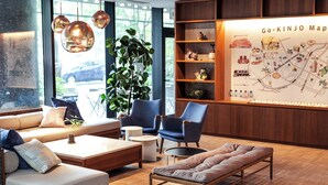A modern hotel lobby with a seating area, a map on the wall, and a large window. - OMO5 Okinawa Naha by Hoshino Resorts (Naha)