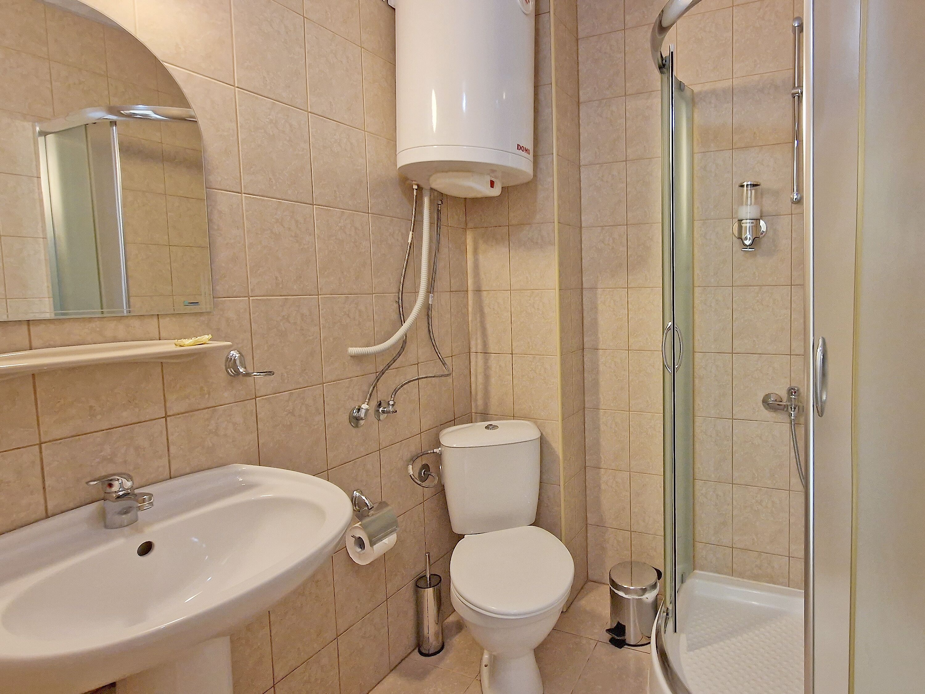A bathroom with a sink, toilet, and shower.