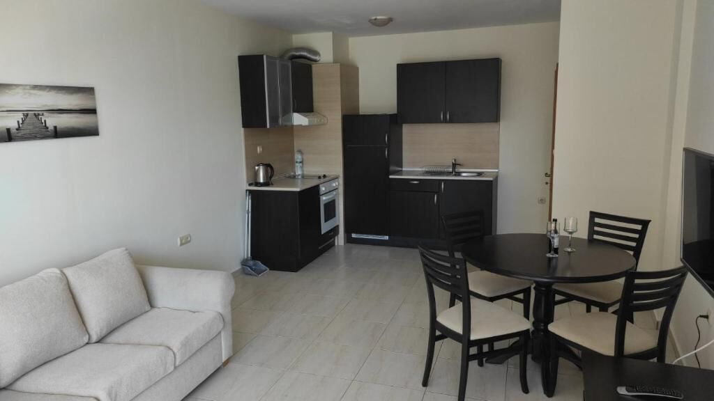 Un espacio habitable compacto con kitchenette, comedor y sofá.