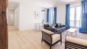 A modern living room with a sofa, two armchairs, a coffee table, and a dining area with a table and chairs. - Free Soul by FeelFreeRentals (San Sebastian)