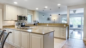 A spacious kitchen with white cabinetry, granite countertops, and a large island. - 5 Loblolly at The Sea Pines Resort (Hilton Head Island)