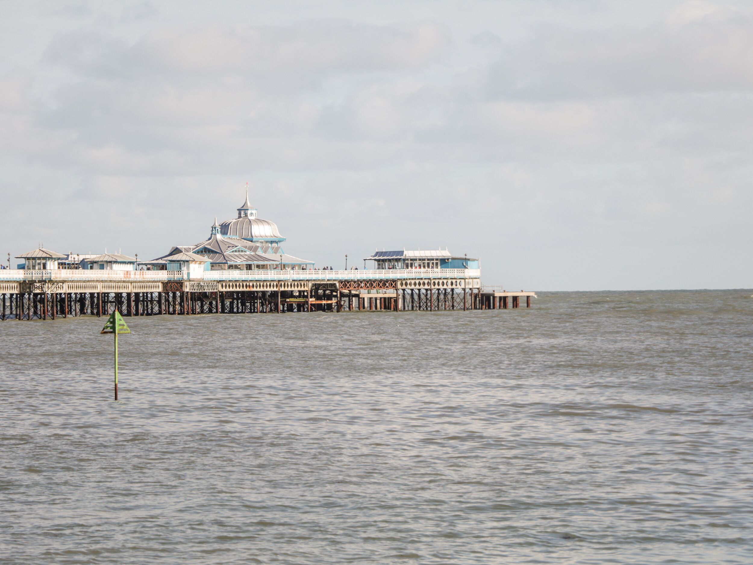 Une jetée s’avançant dans l’eau, sur laquelle se trouve un grand bâtiment doté d’un dôme et de plusieurs étages.