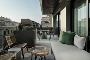 A modern balcony with a sofa, chairs, and a dining table. - MonAsty, Thessaloniki, Autograph Collection (Thessaloniki)