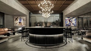 A modern bar area with a central bar, seating around it, and artwork on the walls. - MonAsty, Thessaloniki, Autograph Collection (Thessaloniki)