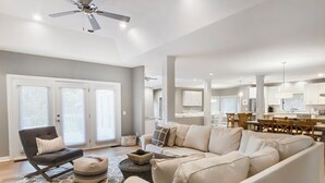 A spacious living room with a large sectional sofa, a dark armchair, and a ceiling fan. - 6 Painted Bunting at The Sea Pines Resort (Hilton Head Island)