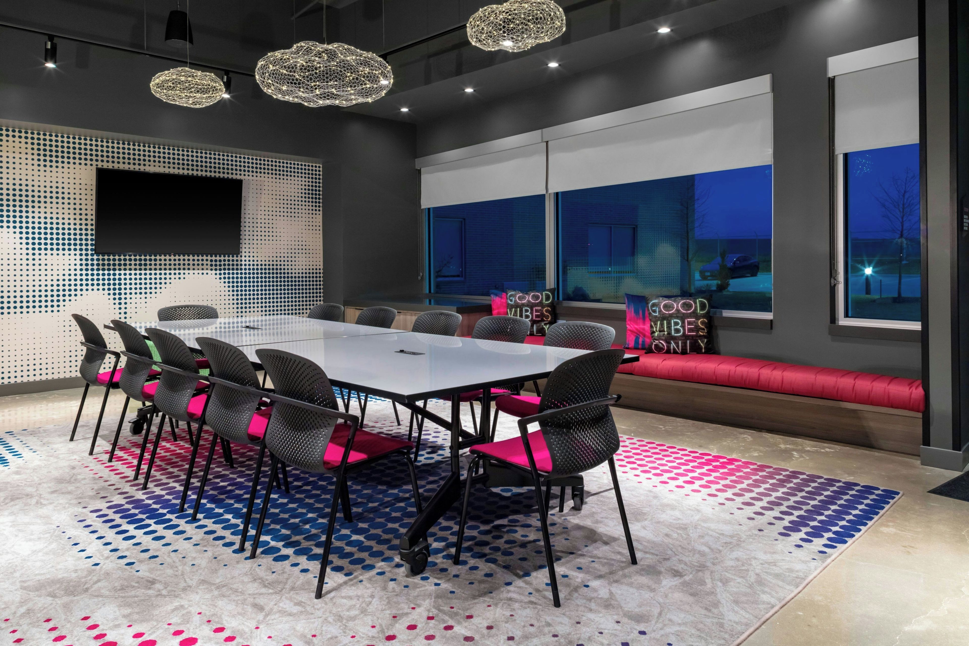Une salle de conférence moderne, dotée d’une grande table, de chaises et d’un canapé.