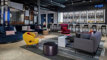A modern lounge area with seating, a bar, and large windows.