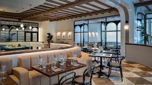 Un restaurante con mostrador curvo, asientos acolchados y amplios ventanales que ofrecen vistas.