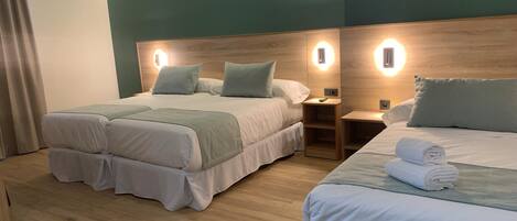 A hotel room with two beds, wooden headboards, bedside tables with lamps, and a neutral color scheme.