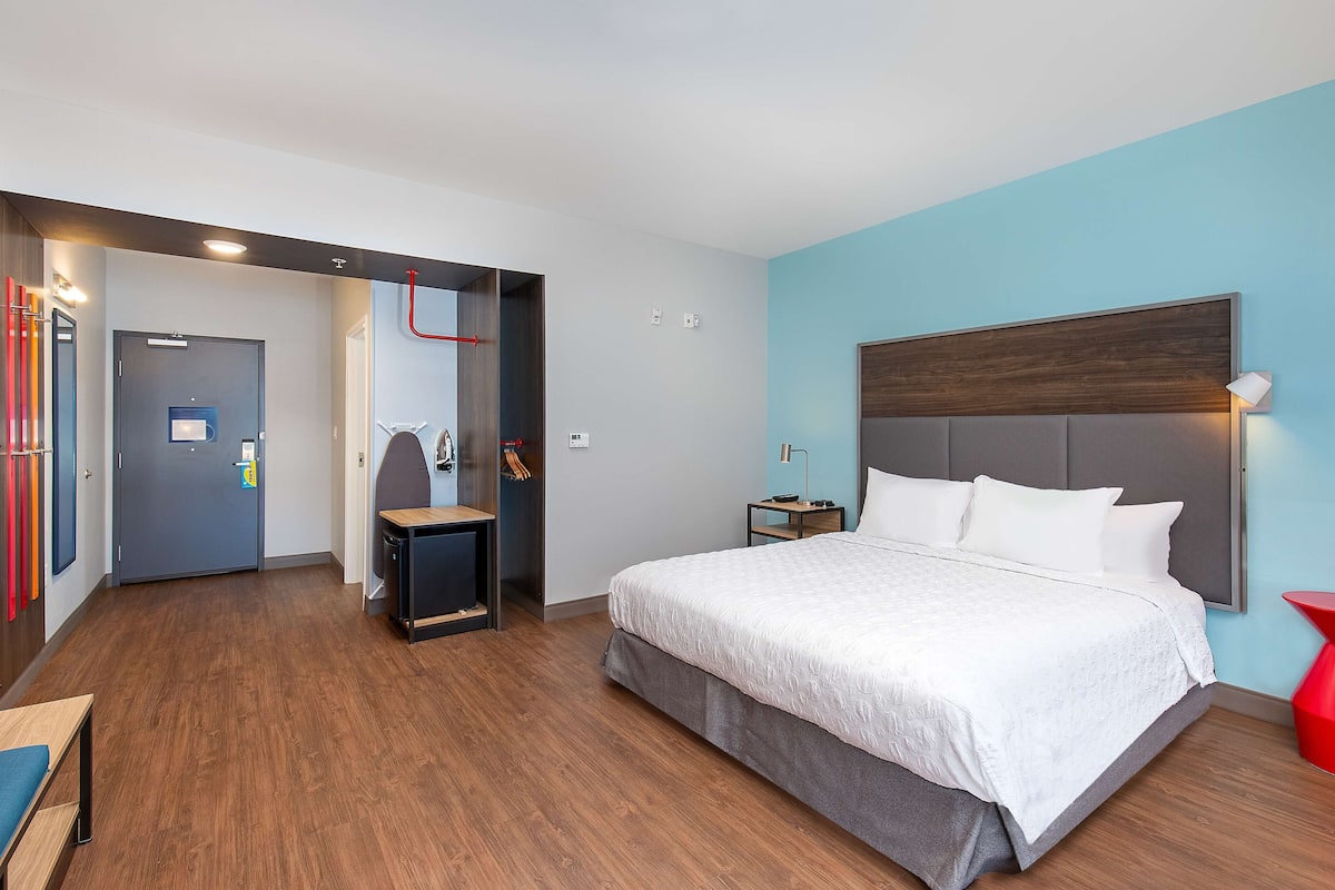 Een hotelkamer met een groot bed, een bureau, een stoel en een kledingkast.