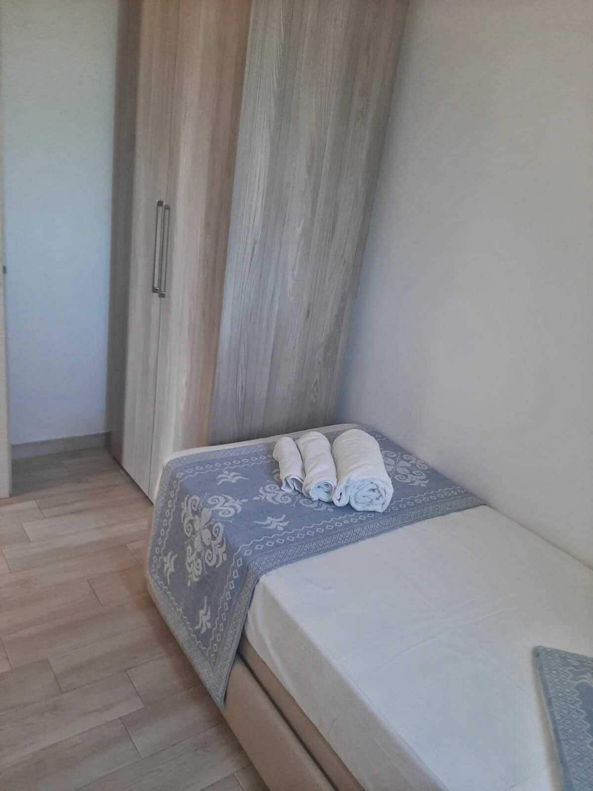 Un dormitorio con cama, armario y edredón estampado.