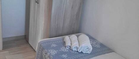 Un dormitorio con cama, armario y edredón estampado.