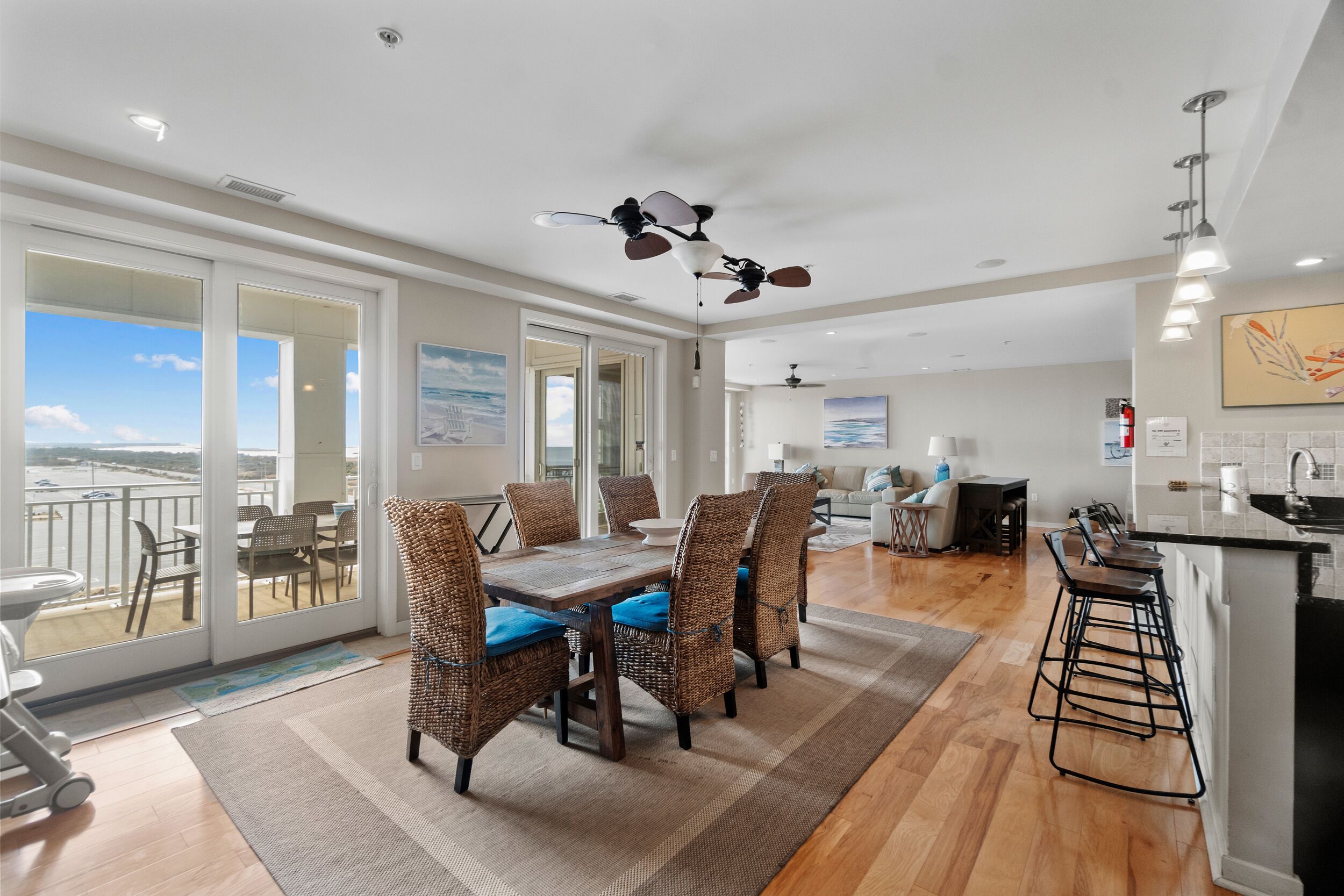 A spacious living area with a dining table, chairs, and a bar area.