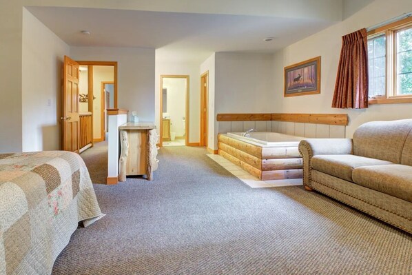 A bedroom with a bed, a sofa, a desk, a chair, a window with curtains, and a painting on the wall.
