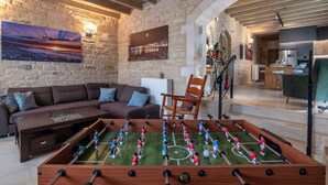 A cozy living room with a foosball table, a sofa, and a coffee table.