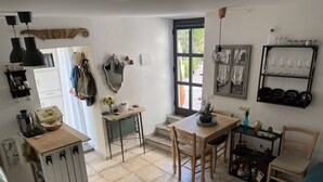 A compact kitchen with a dining area, a coffee machine, and a small table with chairs. - THE SECRET GARDEN (Forza d'Agrò)