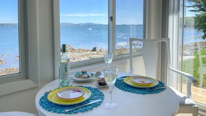 A table set for two with a view of the sea and mountains. - Acadia Bay Cottages (Surry)