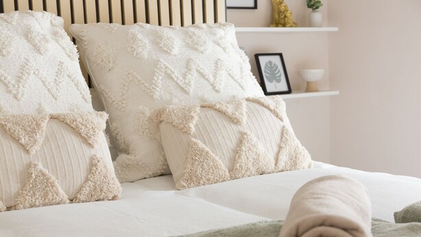 A neatly made bed with rolled towels and decorative pillows. - Bridge Hideaway (Llangollen)