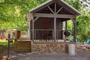 A wooden cabin with a porch, stone foundation, and a grill outside. - Maggie Mountain Charm Close to Downtown (Chattanooga)