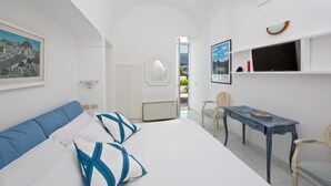 Un dormitorio con cama, escritorio, silla y televisión.
