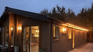 Una cabaña de madera con puerta corrediza de vidrio, un pequeño porche y un letrero que dice "PORTLAND".