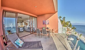 Ein Balkon mit Meerblick, eine Essecke und eine Sitzecke mit Blick.
