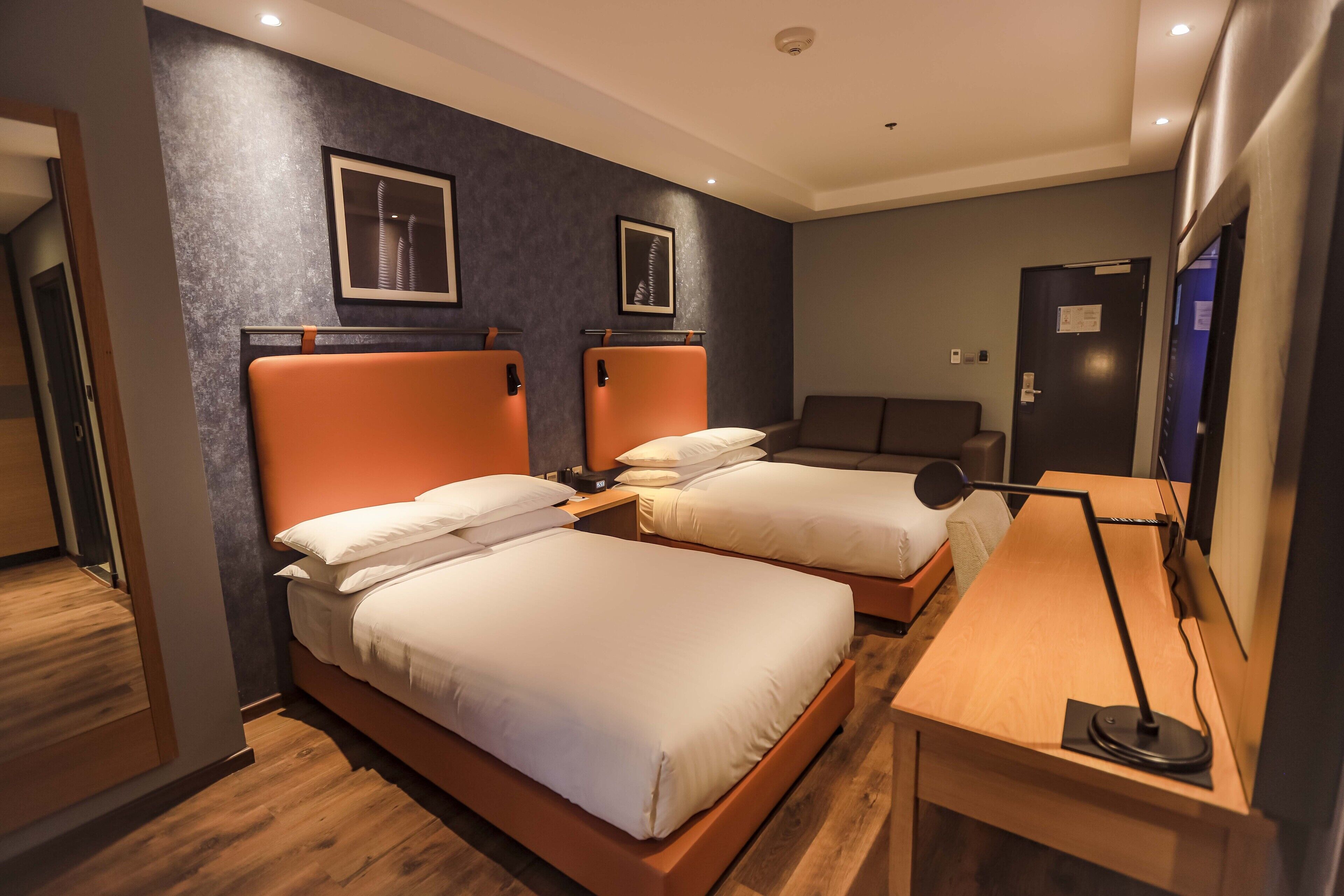 Una habitación de hotel con dos camas, un escritorio y una silla.