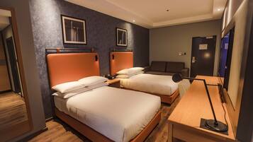 Una habitación de hotel con dos camas, un escritorio y una silla.