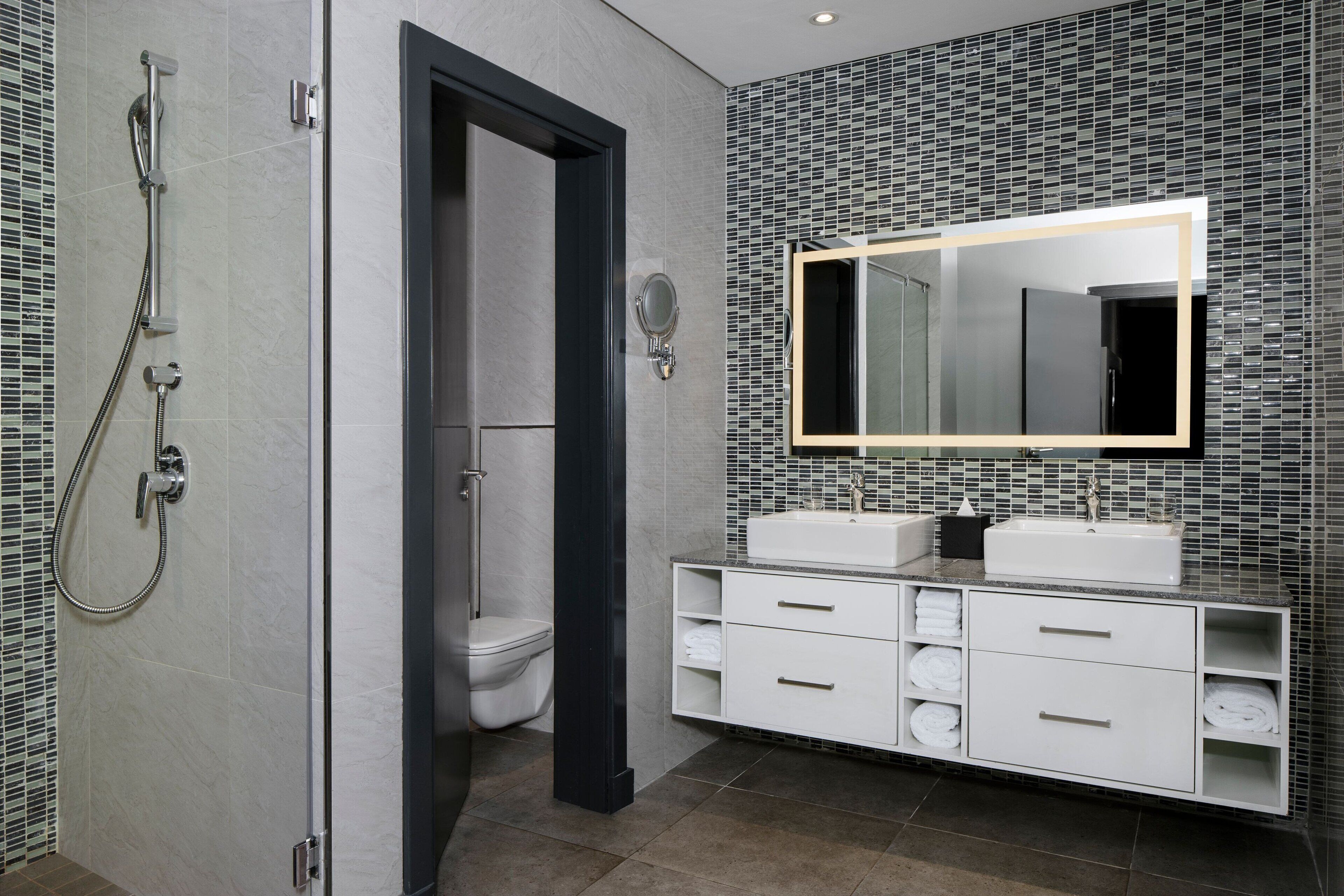 Ein modernes Badezimmer mit Dusche, Toilette und Waschtisch mit Spiegel.