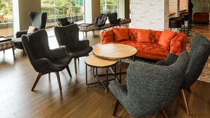 A modern lobby with a mix of seating options, including sofas and chairs, and a large window offering a view of greenery outside. - Four Points by Sheraton Kigali (Kigali)