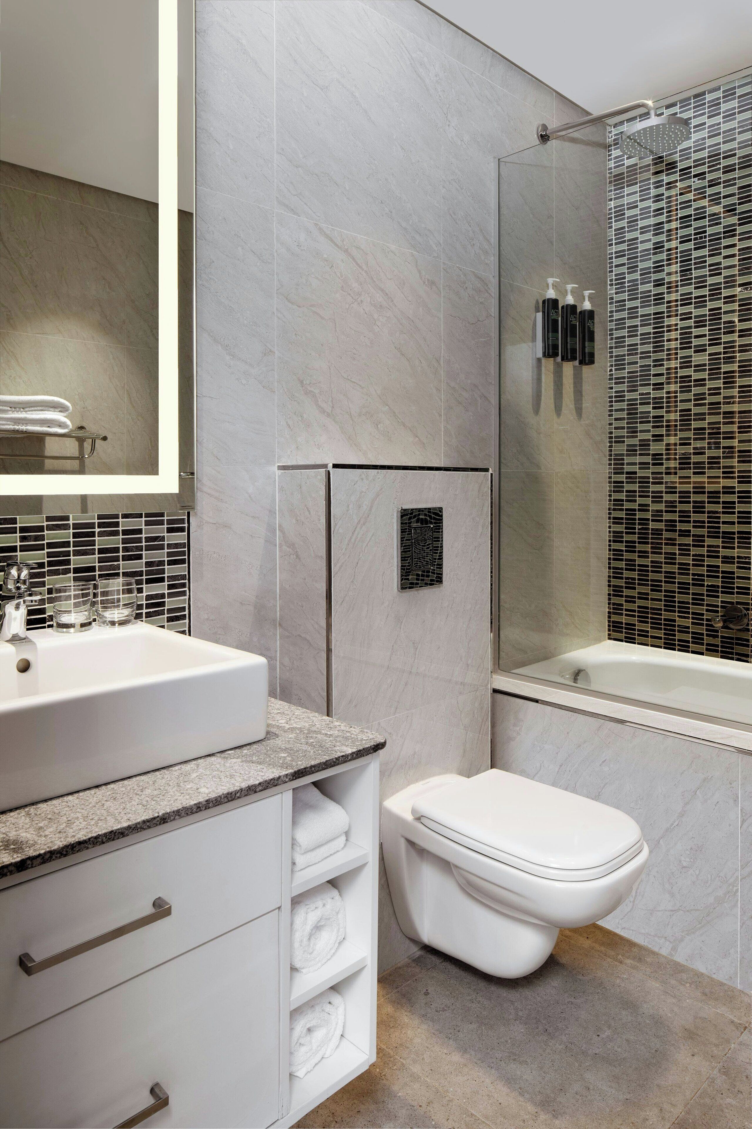 A modern bathroom with a large sink, toilet, and shower area.
