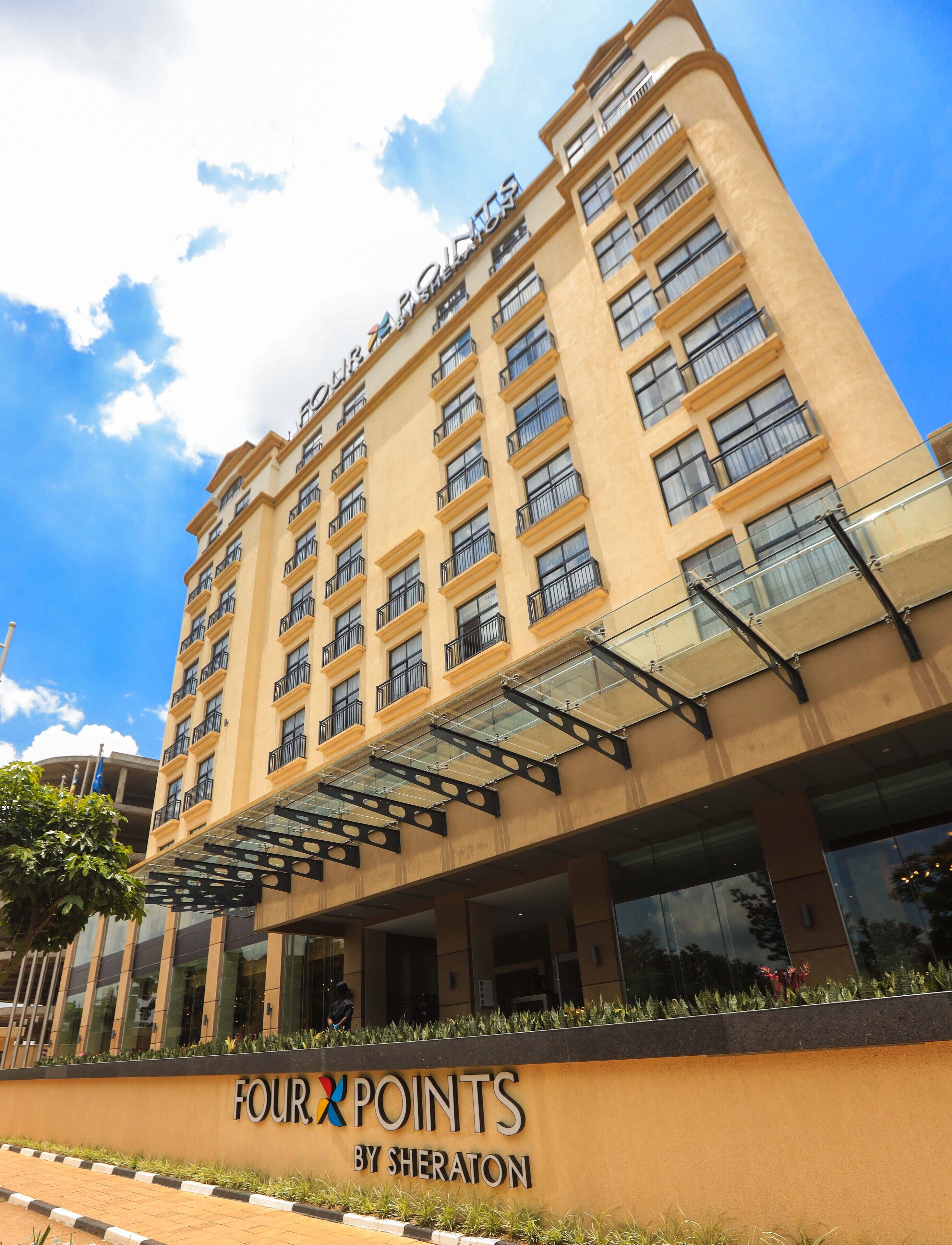 A multi-story hotel with a prominent sign reading "FOUR POINTS BY SHERATON".