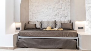 A bed with a headboard, pillows, and a hat on it. - Camares of Castle - Room 2 (Naxos)