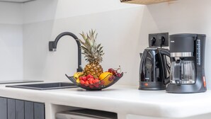 A kitchen with a fruit bowl, a coffee maker, and a sink. - Camares of Castle - Room 2 (Naxos)