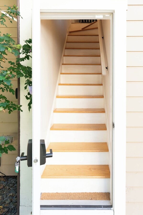 A wooden staircase leading to an upper floor, with a door at the bottom.