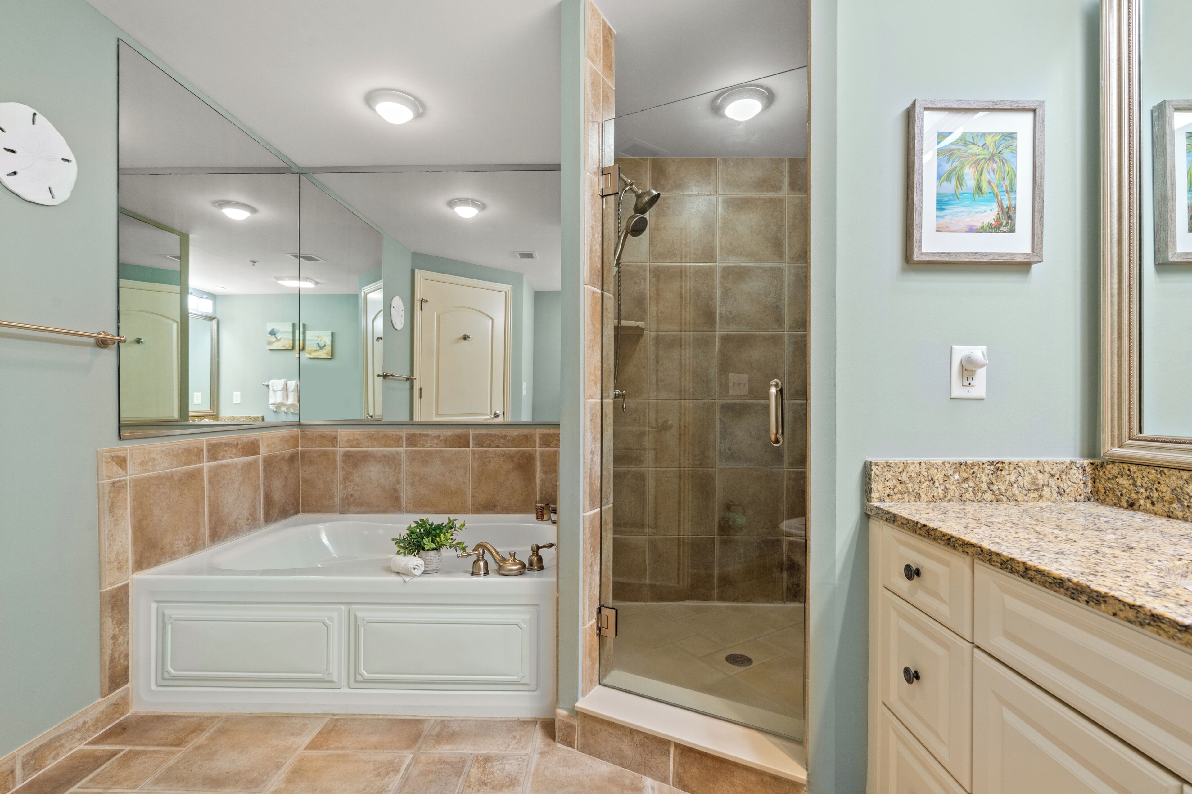 A bathroom with a large bathtub, a walk-in shower, and a vanity with drawers.